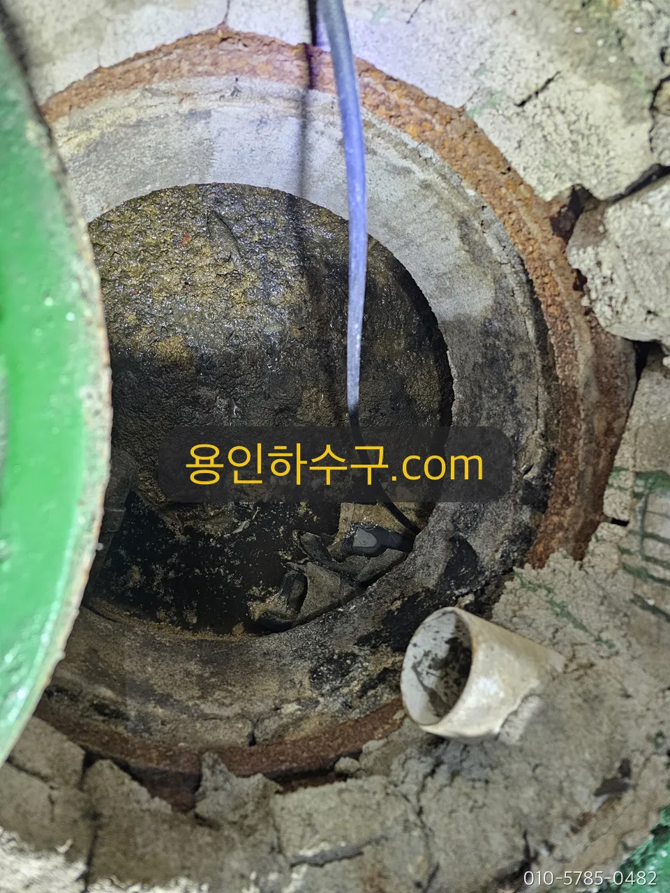 집수정에 세척 호스를 넣어 슬러지를 제거하는 작업
